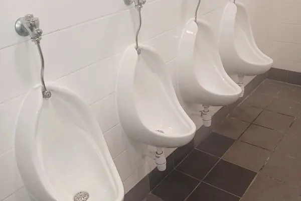 Urinals in a commercial men's bathroom after the waste pipe was rerouted
