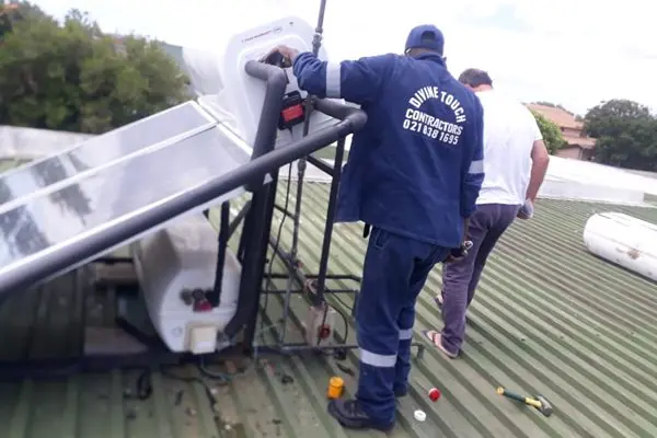Divine Touch plumber installing a solar geyser on a roof in Yzerfontein