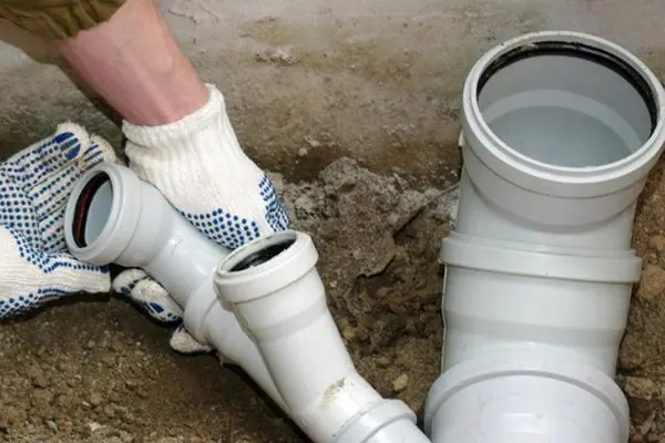 PVC sewer pipe and junction fittings being installed